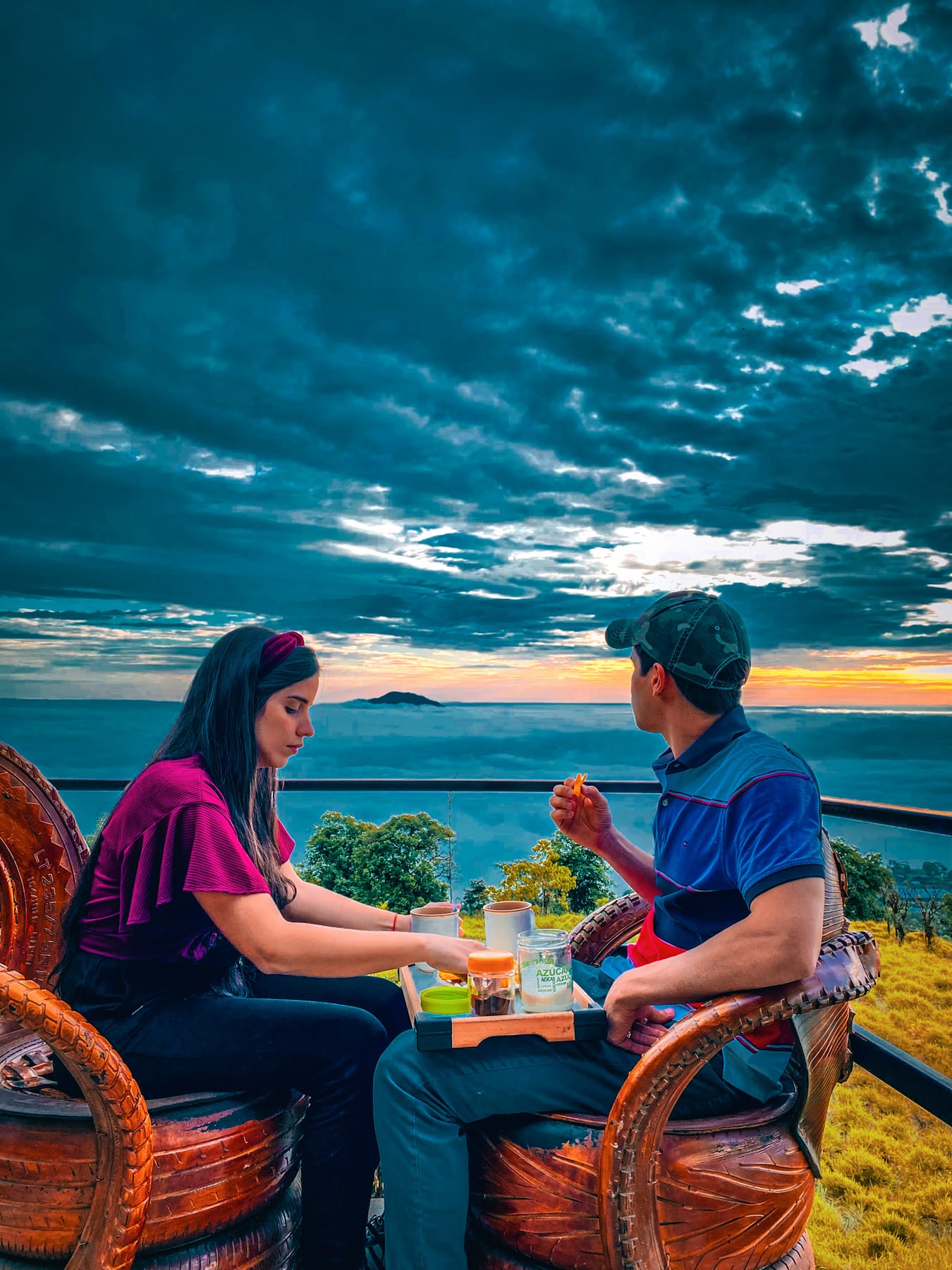 Pareja cenando frente al atardecer y el mar de nubes